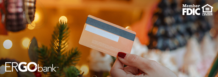 Woman's hand holding out credit card to pay at register