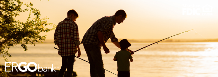 Image shows adult and two children fishing at a lake