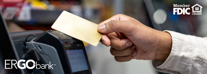 Person tapping their debit card at a point of sale machine at the store