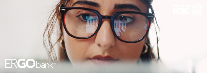 Close up on girl with glasses looking at a computer screen