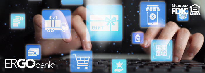 Person's hands on keyboard with shopping icons floating above, cart, gift card, credit card