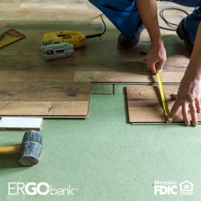 Image of person measuring wooden flooring with other tools scattered on floor