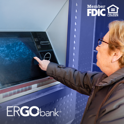 Older woman using an Ergo Bank ITM outside and tapping on the screen with her finger